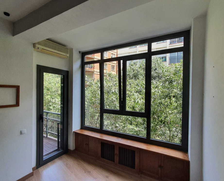 Ventana RPT 70 de perfilería negra con puerta balconera en un salón
